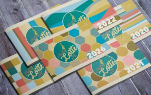 Programmhefte immer im gleichen Design mit verschiedenen Hintergründen auf dem Cover und den Jahreszahlen bis 2026